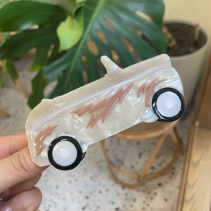 Acetate hair claw clip in a vintage car design with pink flame patterns and marble finish
