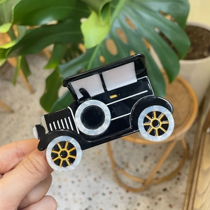 Handheld vintage car-shaped black acetate hair claw clip with pearl and gold accents