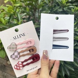 Detail of 6-piece hair clip set with heart charms and wave design on a card