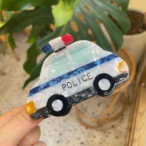 Detail showing marble texture acetate police car hair claw clip with vibrant colors