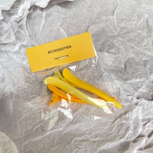 Matte yellow acrylic duckbill hair clips set in a gradient color palette on paper card
