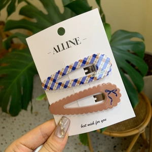 Gros plan d'un ensemble de deux barrettes à cheveux à carreaux et au design ondulé