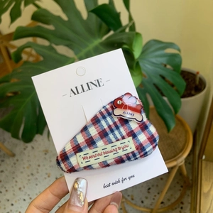 Sweet red and blue plaid wool bunny hair clip with heart detail on a display card