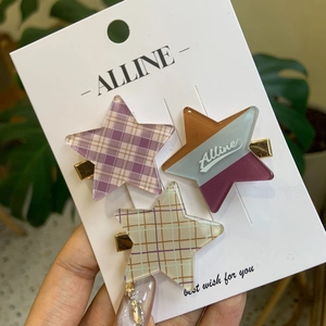 Détail de pinces à cheveux en forme d'étoile aux motifs à carreaux violets et verts