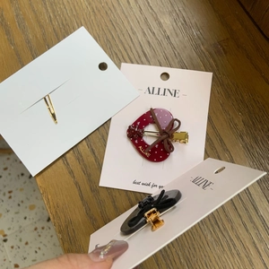 Détails de barrettes à cheveux avec cœur et nœud sur cartes sur fond de bois