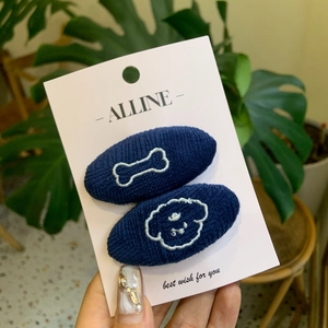 Deep blue knitted hair clips with white bone and dog embroidery on card holder