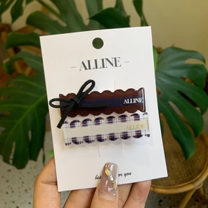 Detail view of coffee bow and lilac plaid hair clips on white display card
