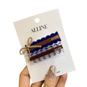 Checkered and navy blue bow hair clips with gold logo for vintage aesthetic hairstyle