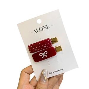Polka dot and bow hair clip set with sparkling rhinestones on a white display card
