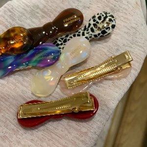 Macro view of colorful acetate bow hair clips with gold metal fasteners and French handmade text