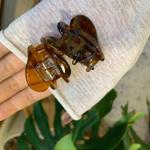 Detail showing amber tortoise shell hair claw clips in medium and small sizes