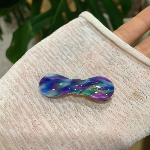 Detail of handmade acetate hair clip with blue marble pattern and gold France logo
