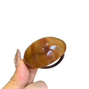 Minimalist tortoiseshell acetate hair tie with amber oval piece and elastic band