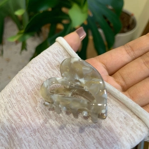 Detail of handmade acetate heart hair claw clip with elegant marble pattern