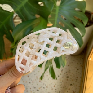 Pince à cheveux en acétate marbré rose avec motif tressé et détail logo doré
