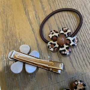 Detail of leopard print flower hair tie and grey resin hair clip with tiny rhinestones
