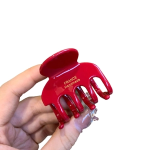 Glänzende rote Acetat Haarklammer mit Goldaufdruck France Handmade auf weißem Grund