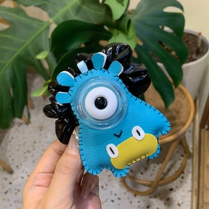Détail d'un chouchou monstre coloré en similicuir avec un grand décor d'oeil blanc