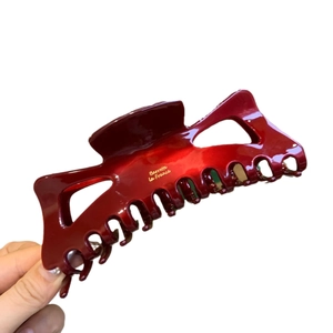 Elegante molletta per capelli in acetato bordeaux con logo dorato e finitura lucida