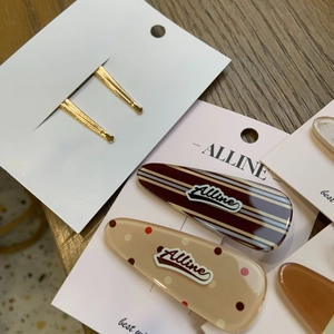 Close-up of duckbill hair clips with plaid and polka dot patterns on a wooden background