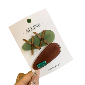 Set of green oval and brown teardrop hair clips with ribbon detail and metal base