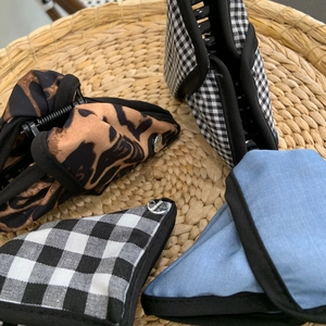 Detail of fabric hair claws featuring leopard print and plaid with Hand Made metal button
