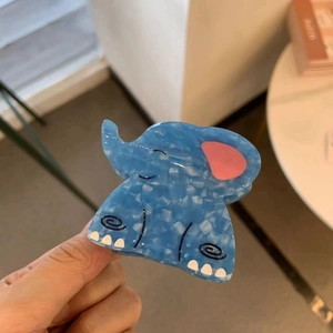 Detail of light blue elephant hair claw clip with mosaic pattern and pink ear accent