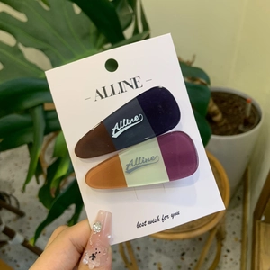 Set of two stylish teardrop hair clips with plaid patterns and logo on display card