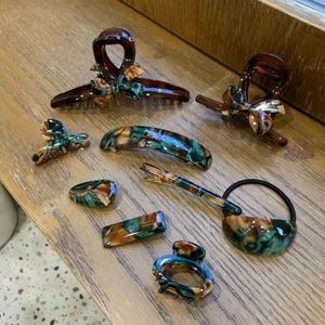 Flat lay of vintage tortoise acetate hair claw clips and ties on a wooden surface