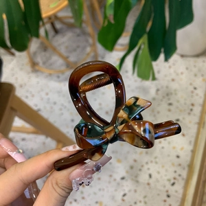 Large amber marble acetate hair claw clip with elegant bow design for thick hair