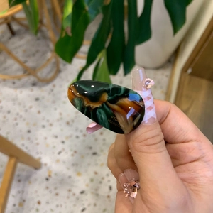 Detailed macro view of high-quality marbled acetate hair clip with polished finish
