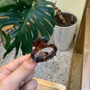 Detailed view of an oval tortoiseshell hair claw clip with amber and black pattern
