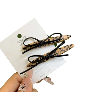 Pair of leopard print bow hair clips on display card with a black knotted ribbon design