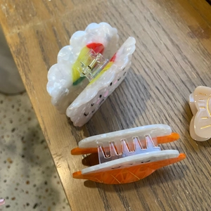 Détail de deux pinces à cheveux en forme de sushi avec expressions mignonnes sur bois