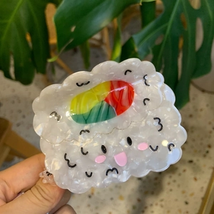 Détail de la pince à cheveux nuage avec finition nacrée et visage de dessin animé mignon