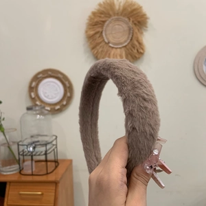 Detail of a brown plush headband with thick soft faux fur and wide design for women