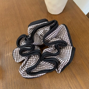 Classic brown and white gingham scrunchie with black trim on a wooden background