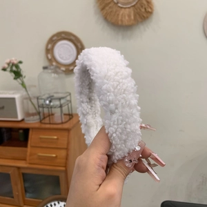Nahaufnahme des flauschigen weißen Sherpa-Teddy-Stirnbandes mit weicher Plüschstruktur