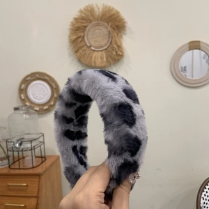 Gros plan d'un serre-tête en peluche léopard montrant la texture douce en fausse fourrure