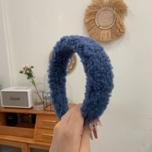 Nahaufnahme eines blauen Plüsch-Haarreifens aus weichem Teddy-Fleece für Damenfrisuren
