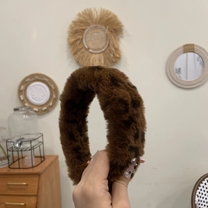 Détail du serre-tête large à motif léopard avec une texture en peluche douce