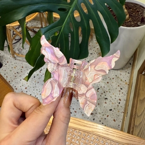 Textured pink marble butterfly hair claw clip featuring elegant acrylic wings and golden spring
