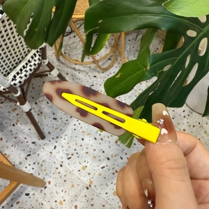 Détail de la pince à cheveux léopard avec motif tortue et clip en métal jaune vif