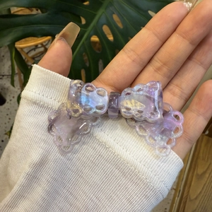 Detail of purple lace bow hair clip with shimmering iridescent pearlescent finish