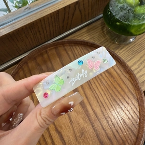 Pince à cheveux papillon en acétate élégante avec strass colorés sur une base nacrée