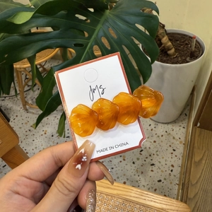 Lot de barrettes à cheveux en forme de coquillage orange sur carte de présentation