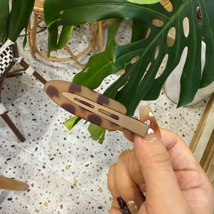 Détail d'une pince à cheveux léopard avec clip bec de canard en fini mat beige