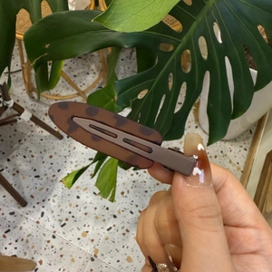 Gros plan d'une barrette à cheveux imprimé léopard en résine de qualité supérieure