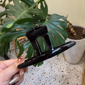 Détail d'une grande pince à cheveux noire brillante pour coiffer les cheveux épais