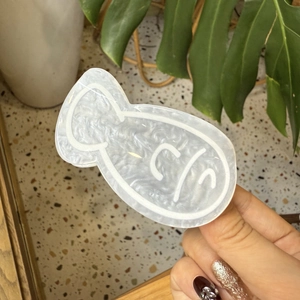 Close-up of fish-shaped acrylic hair claw clip with pearlescent mica texture finish